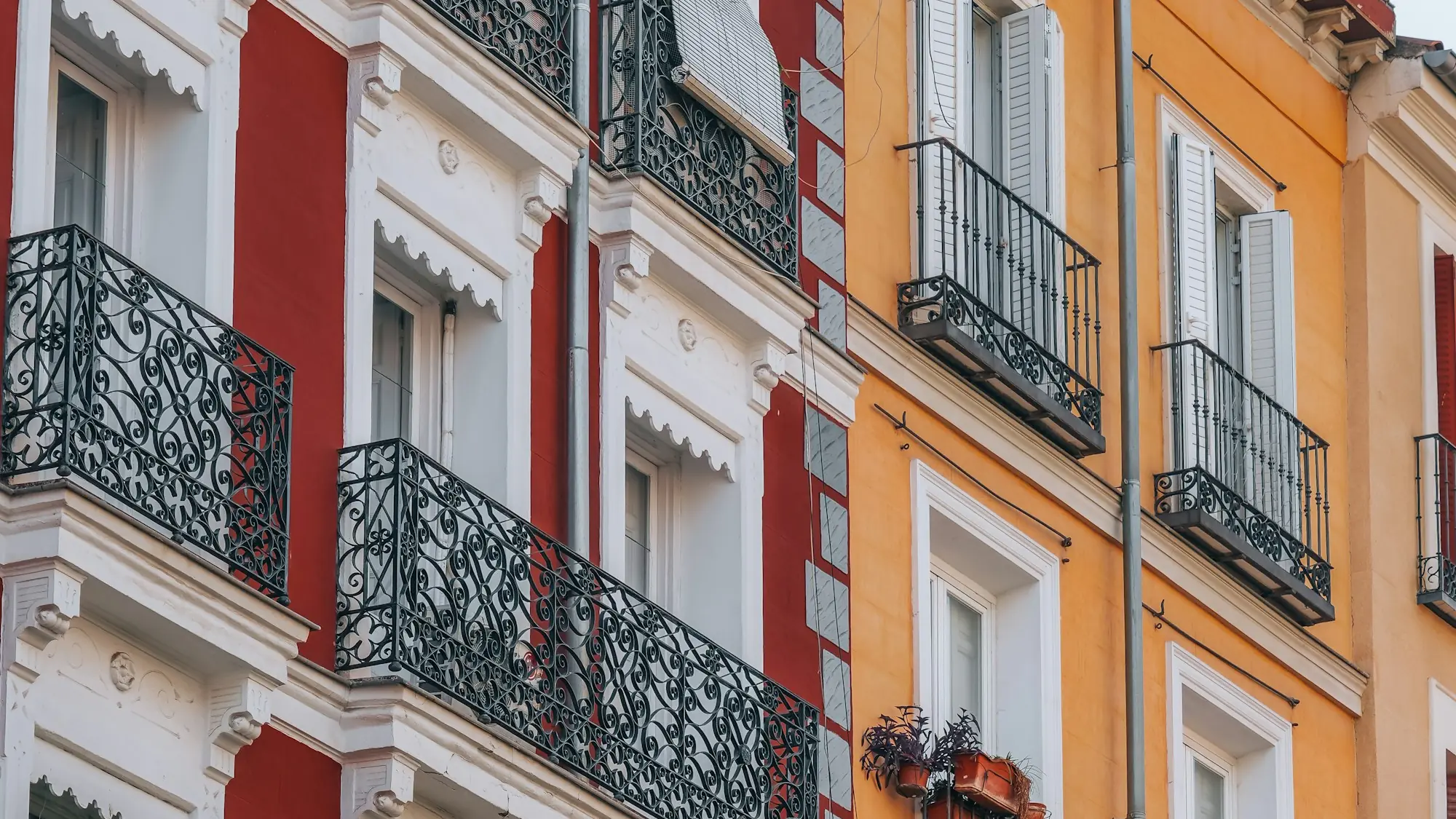 Fachada de un edificio de viviendas con balcones de forja y contraventanas