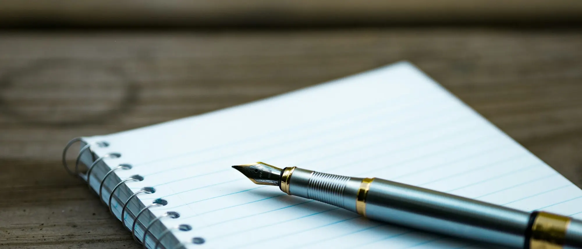 Pluma estilográfica apoyada sobre un cuaderno abierto